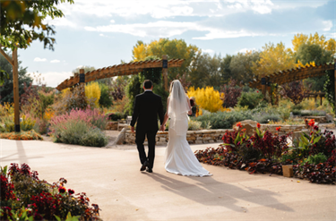 bride and groom kissing on a lawn surrounded by bubbles