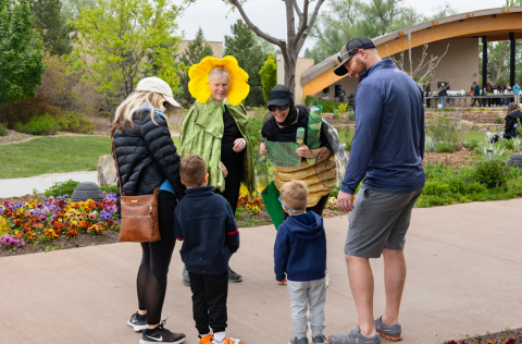 Family interacting with adults dressed as pollinators